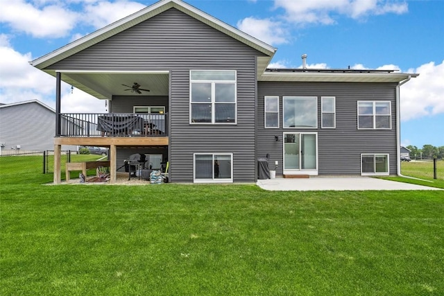 back of house featuring a lawn, ceiling fan, a patio, and a deck