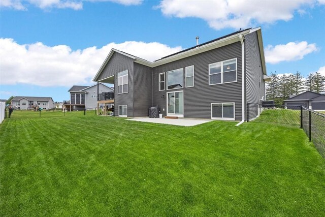 back of house featuring a lawn and a patio area