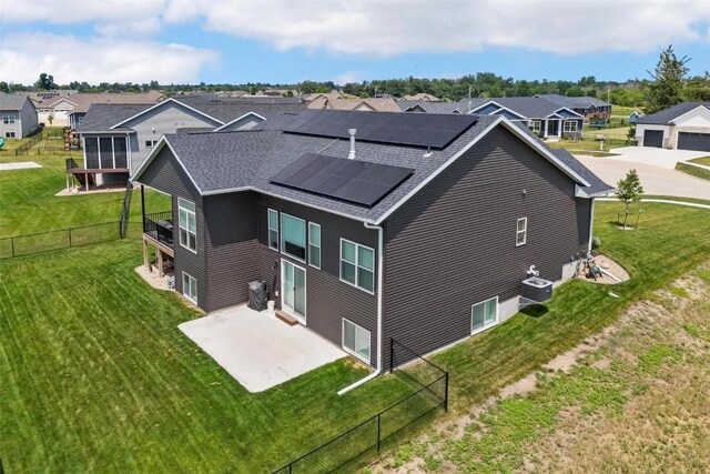 exterior space featuring solar panels, a patio, cooling unit, and a lawn