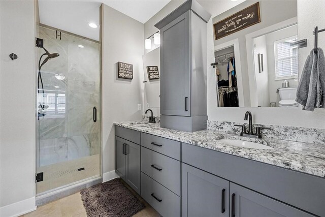 bathroom with tile patterned floors, vanity, toilet, and walk in shower