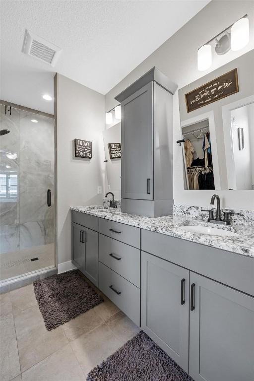 bathroom with vanity, a textured ceiling, and walk in shower