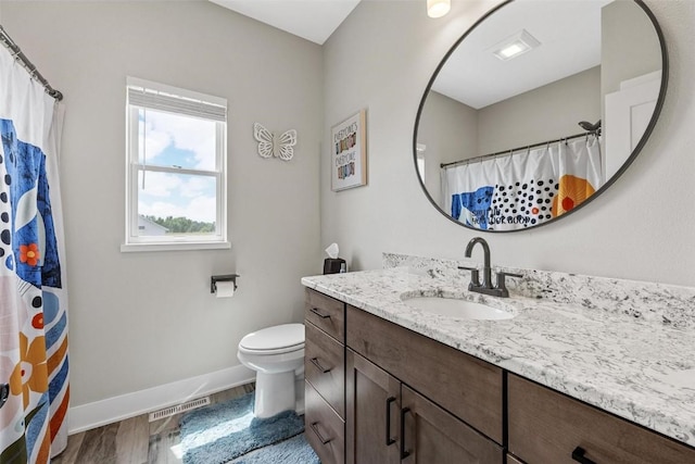 full bathroom with vanity, wood finished floors, baseboards, visible vents, and toilet