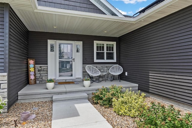 entrance to property with stone siding and covered porch