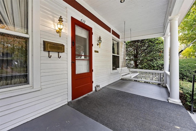 view of exterior entry featuring covered porch