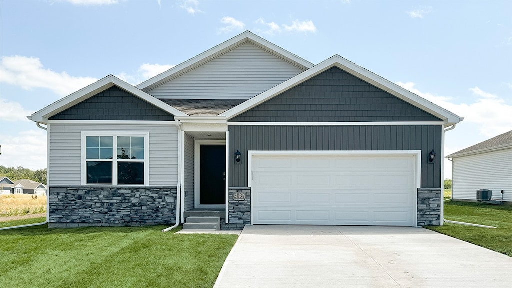 craftsman inspired home featuring cooling unit, a front yard, and a garage