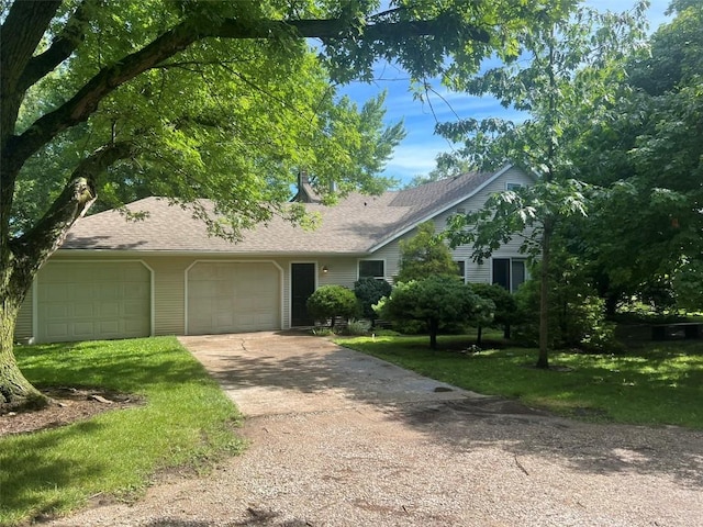 ranch-style house with a garage, a front yard, roof with shingles, and driveway