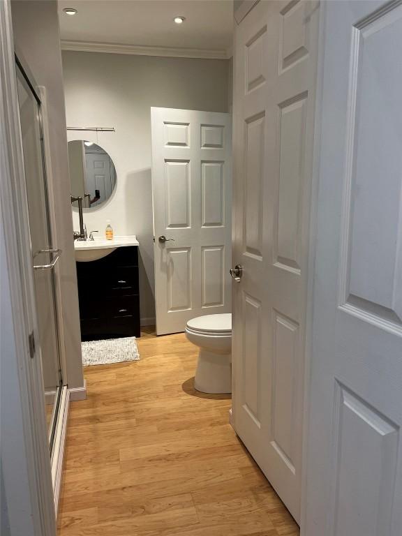 bathroom featuring crown molding, vanity, toilet, and wood finished floors