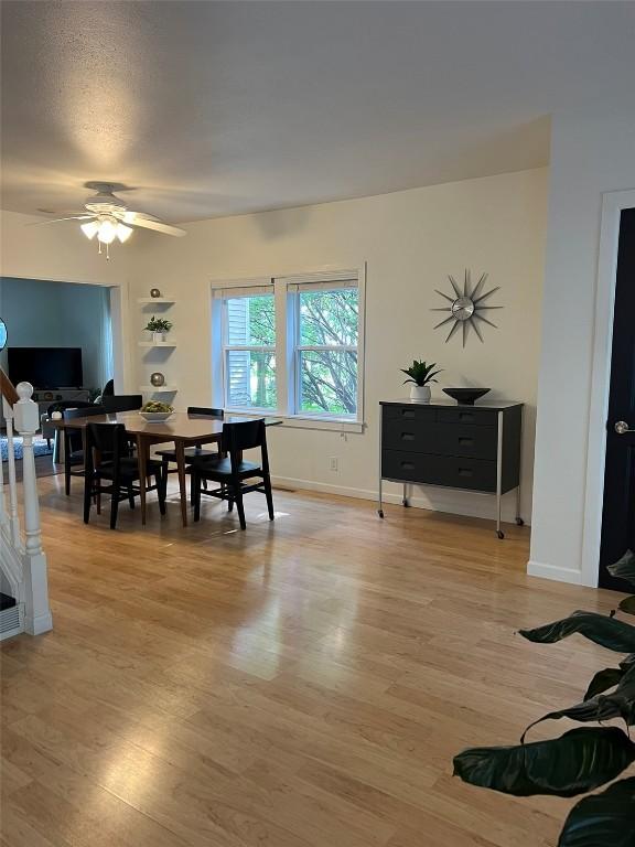 dining area with ceiling fan, stairway, baseboards, and wood finished floors