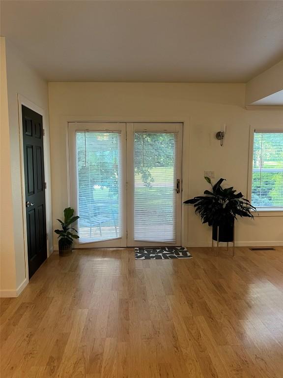 doorway to outside with light wood-style flooring and baseboards