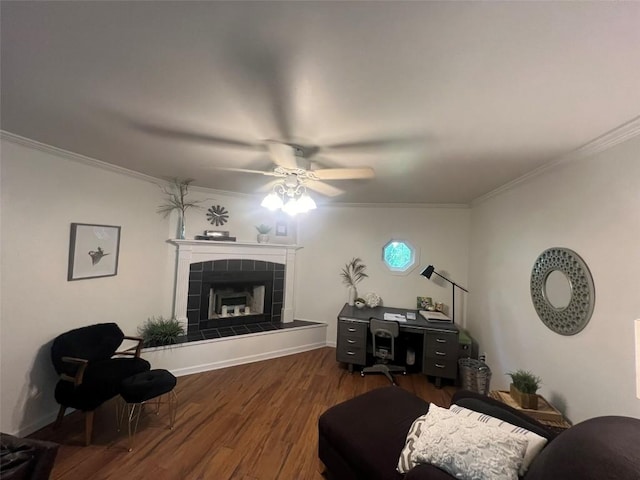 living room with dark wood-type flooring, a tile fireplace, and crown molding