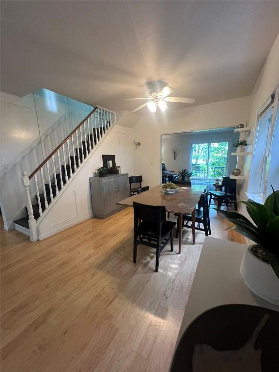 dining area with stairs, wood finished floors, and a ceiling fan