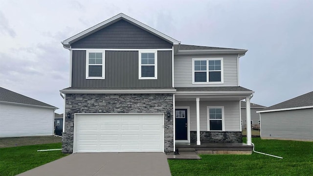 view of front facade featuring stone siding, a porch, concrete driveway, a front yard, and a garage