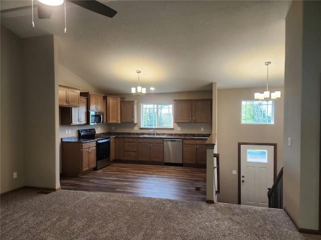 kitchen featuring dark colored carpet, hanging light fixtures, ceiling fan with notable chandelier, and appliances with stainless steel finishes