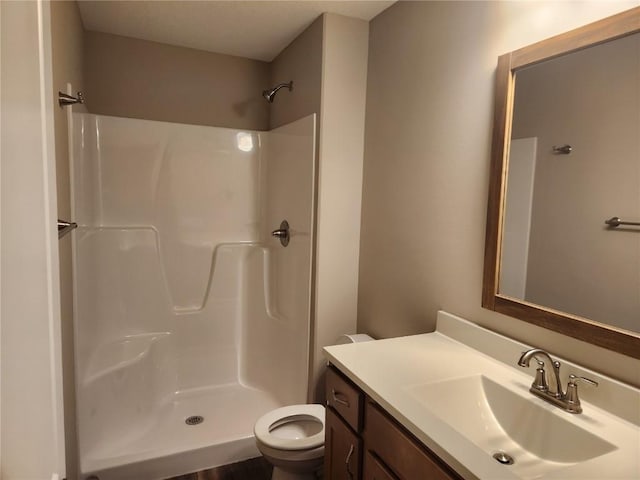 full bath featuring toilet, a shower, and vanity