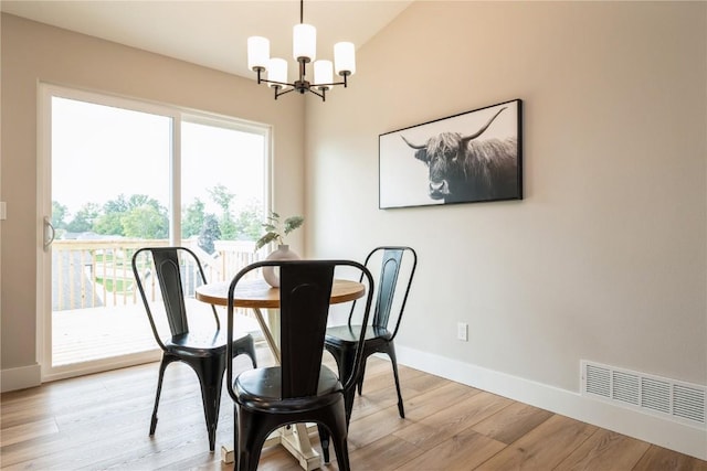 dining room with light wood-style floors, visible vents, baseboards, and an inviting chandelier