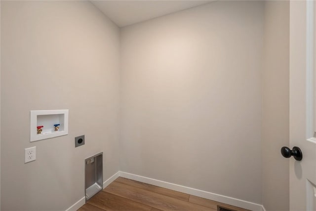 laundry room featuring hookup for a washing machine, hookup for an electric dryer, wood finished floors, laundry area, and baseboards