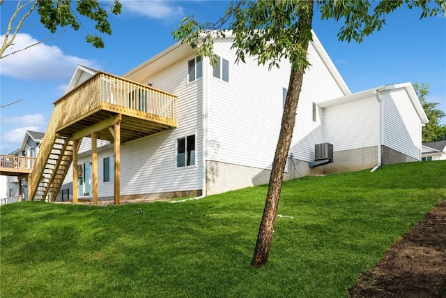 rear view of house with a yard, a deck, and stairs