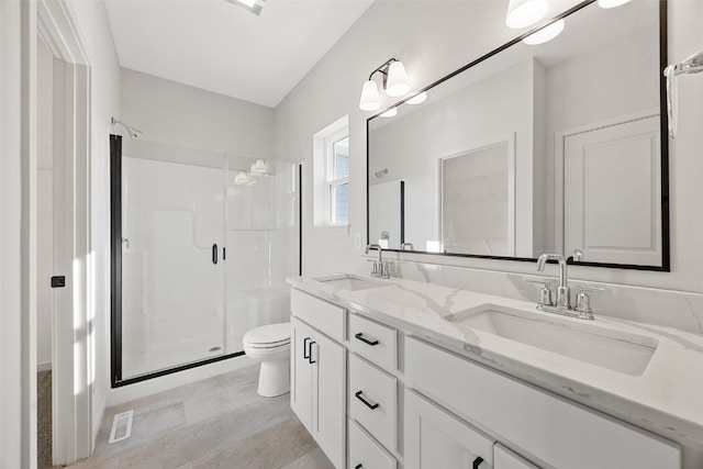 bathroom with vanity, a shower with shower door, and toilet