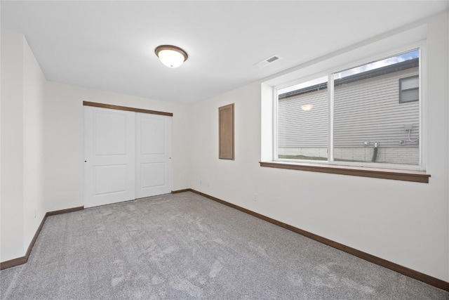 unfurnished bedroom with a closet and light colored carpet