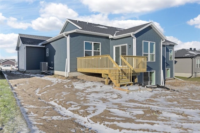 rear view of property featuring central AC unit and a wooden deck