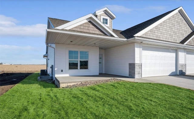 view of front of property with a garage, covered porch, a front yard, and central air condition unit