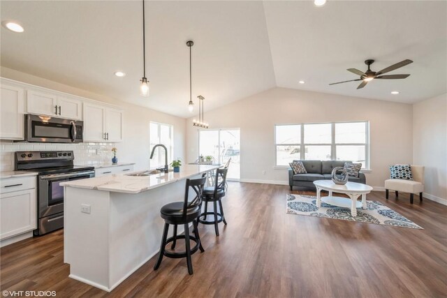 kitchen featuring decorative light fixtures, sink, white cabinetry, and stainless steel appliances