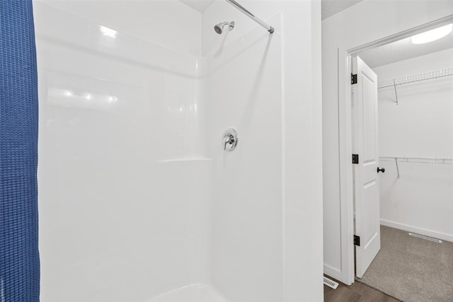 bathroom with a shower and hardwood / wood-style flooring