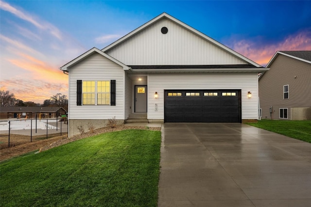 view of front of property featuring a garage and a lawn