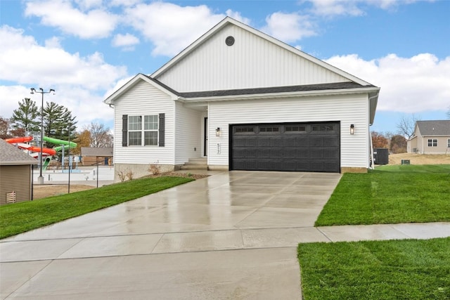 view of front of property featuring a garage, a front lawn, and central air condition unit