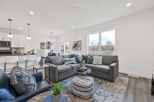 living room featuring a notable chandelier and dark hardwood / wood-style flooring