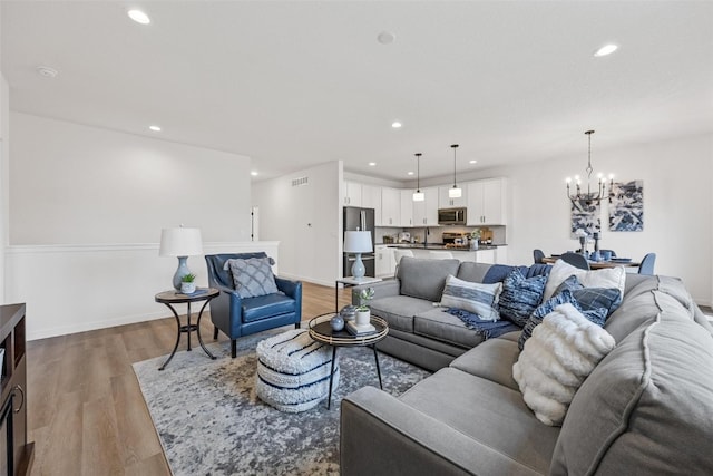 living room featuring an inviting chandelier and hardwood / wood-style floors