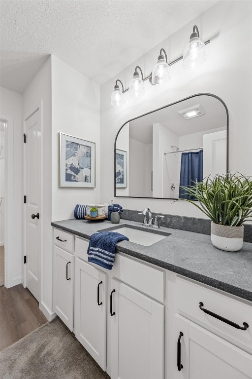 bathroom featuring vanity, a textured ceiling, a shower with shower curtain, and wood-type flooring