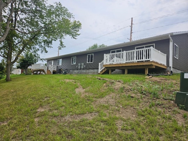 back of house featuring a yard and a deck