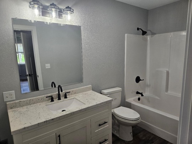 full bathroom featuring hardwood / wood-style flooring, vanity, toilet, and  shower combination