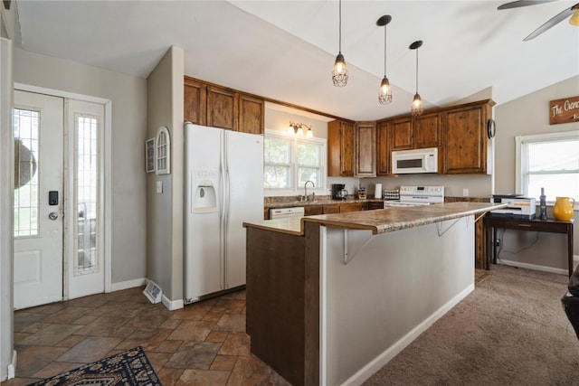 kitchen with white appliances, vaulted ceiling, a wealth of natural light, and a breakfast bar