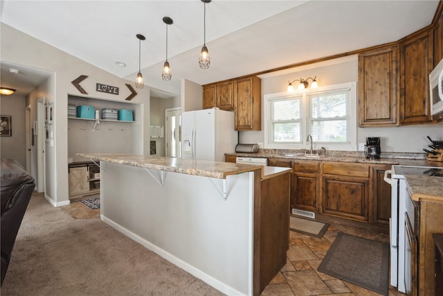 kitchen with a kitchen breakfast bar, a center island, decorative light fixtures, light colored carpet, and white appliances