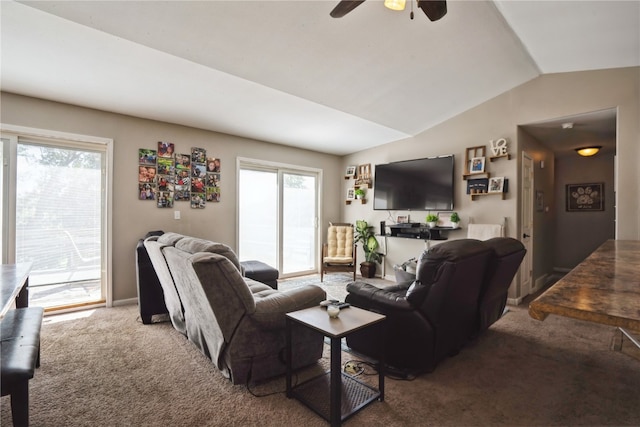 carpeted living room with vaulted ceiling, ceiling fan, and plenty of natural light