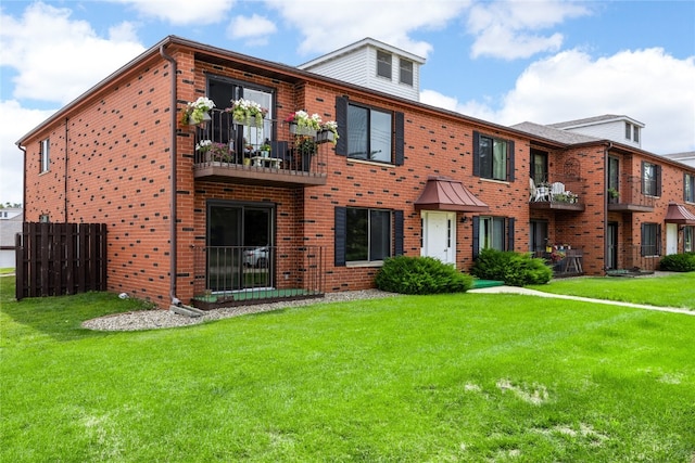 view of front facade featuring a balcony and a front lawn