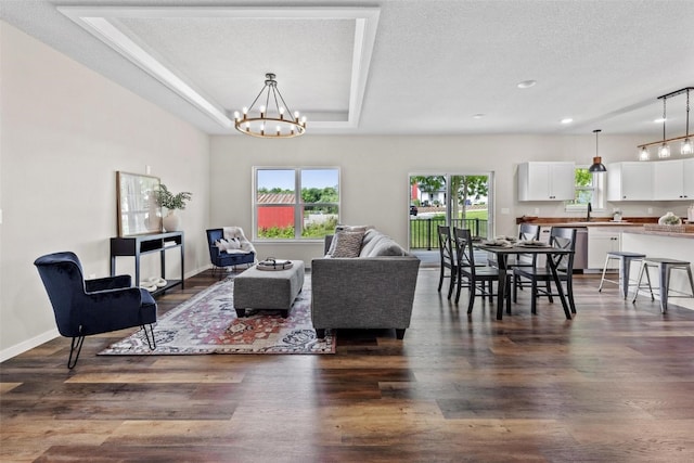 living room with dark hardwood / wood-style flooring, a textured ceiling, and sink