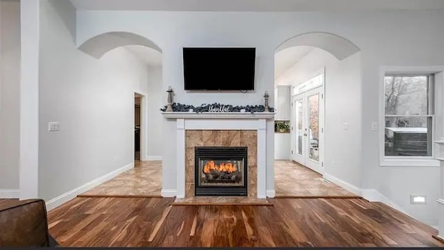 unfurnished living room featuring a tile fireplace and hardwood / wood-style floors