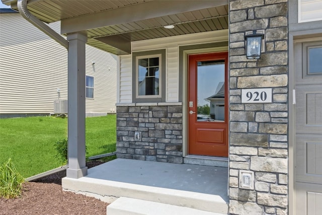 entrance to property with a porch and a yard