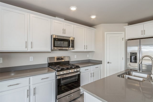 kitchen featuring white cabinets, stainless steel appliances, and sink