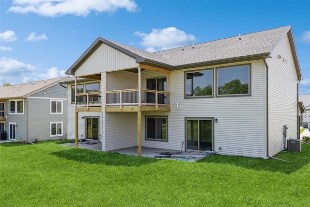 back of property with a yard, a balcony, a patio, and central AC