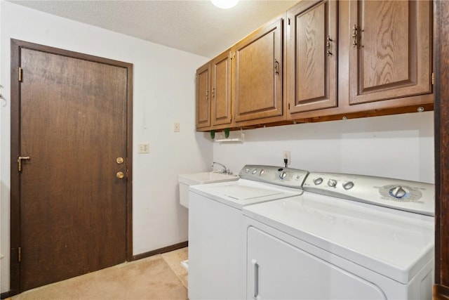 washroom with cabinets, washer and dryer, sink, and a textured ceiling