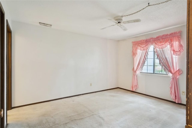 unfurnished room featuring light carpet, a textured ceiling, and ceiling fan