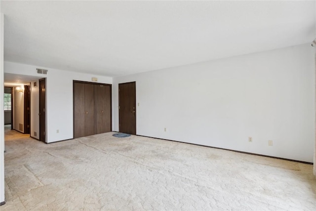 unfurnished bedroom with light carpet and a closet