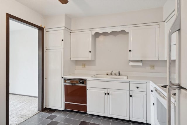 kitchen featuring ceiling fan, white appliances, sink, and white cabinets