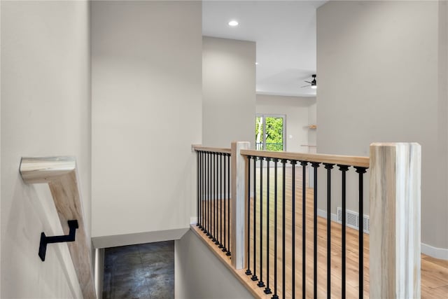 stairs with hardwood / wood-style flooring and ceiling fan