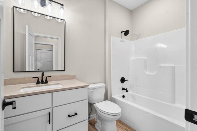 full bathroom featuring vanity, toilet, hardwood / wood-style floors, and tub / shower combination