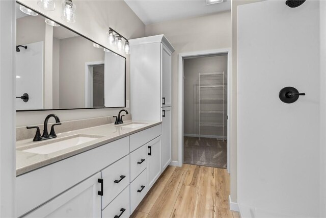 bathroom featuring hardwood / wood-style floors and dual bowl vanity